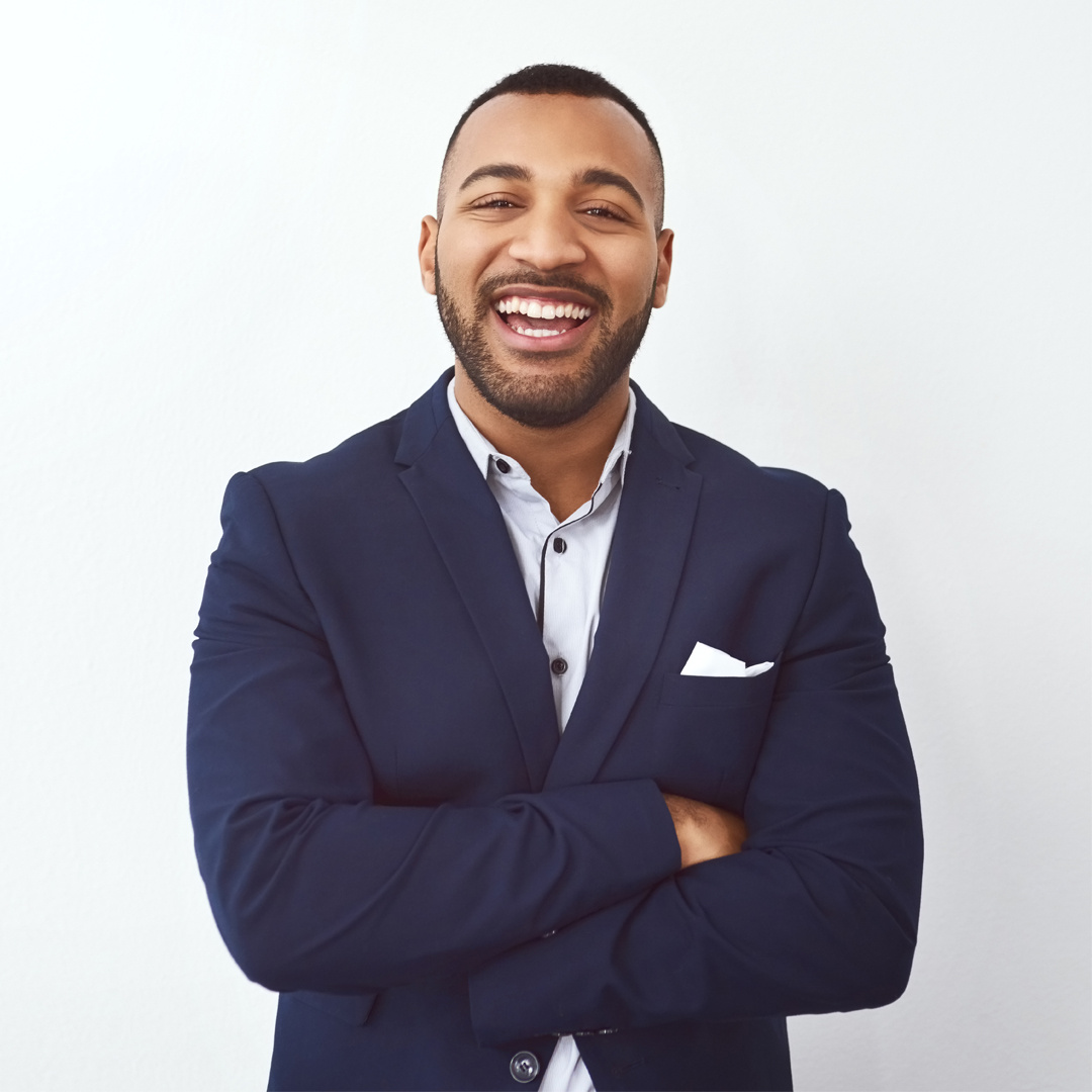 Male property manager in a suit smiling while posing for a photo